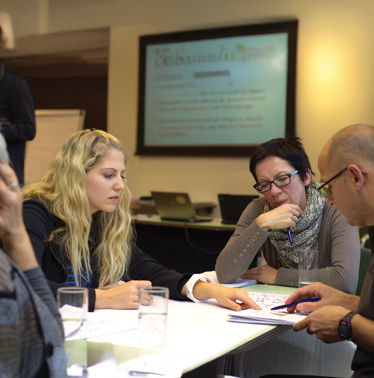 Group of adults meeting around a table looking at paperwork